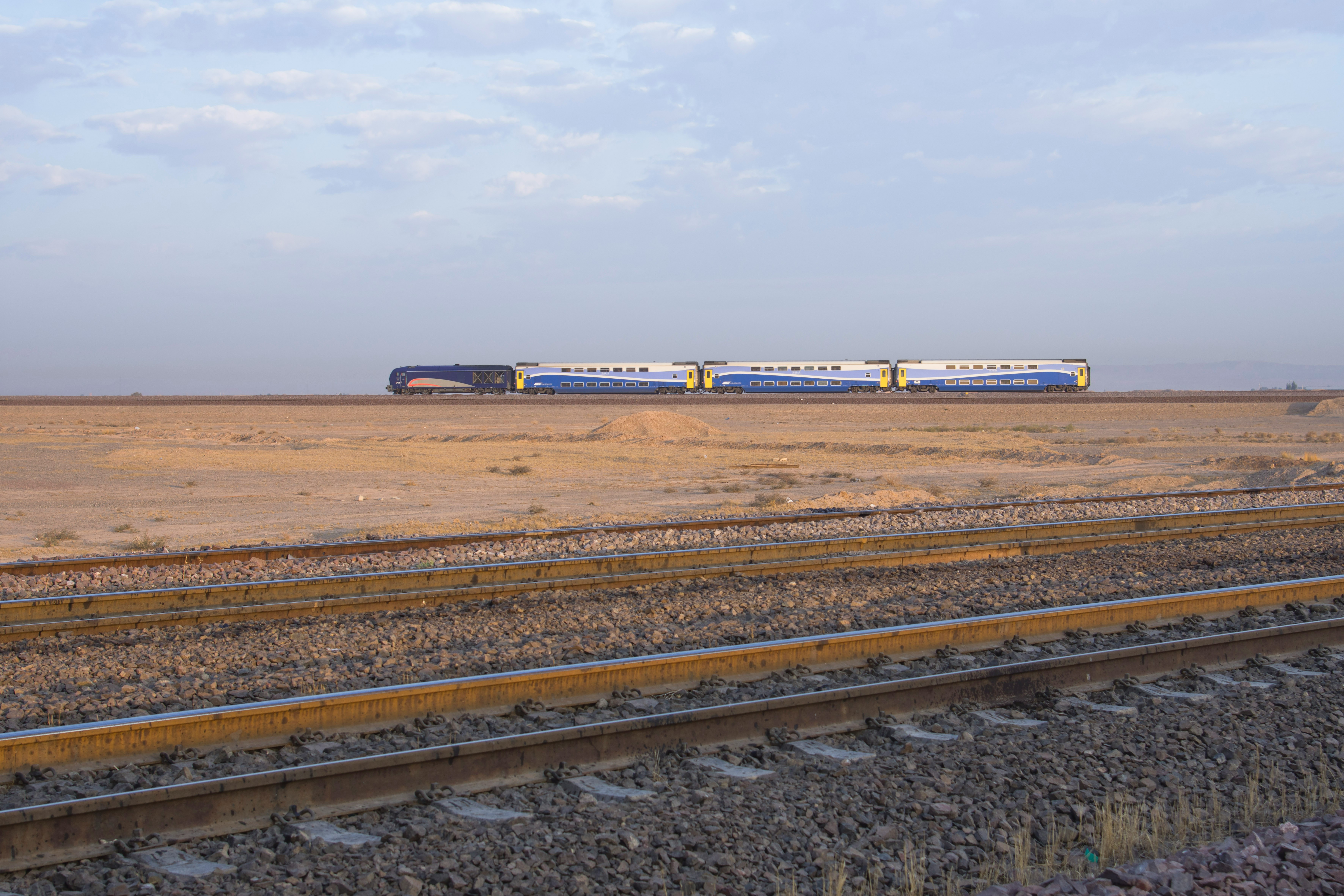 blue and white train on rail track during daytime